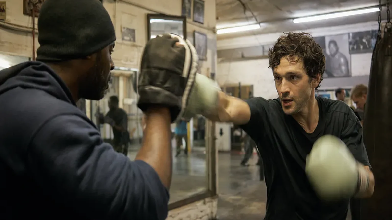 Actor or dancer working controlled pad combinations with a boxing coach