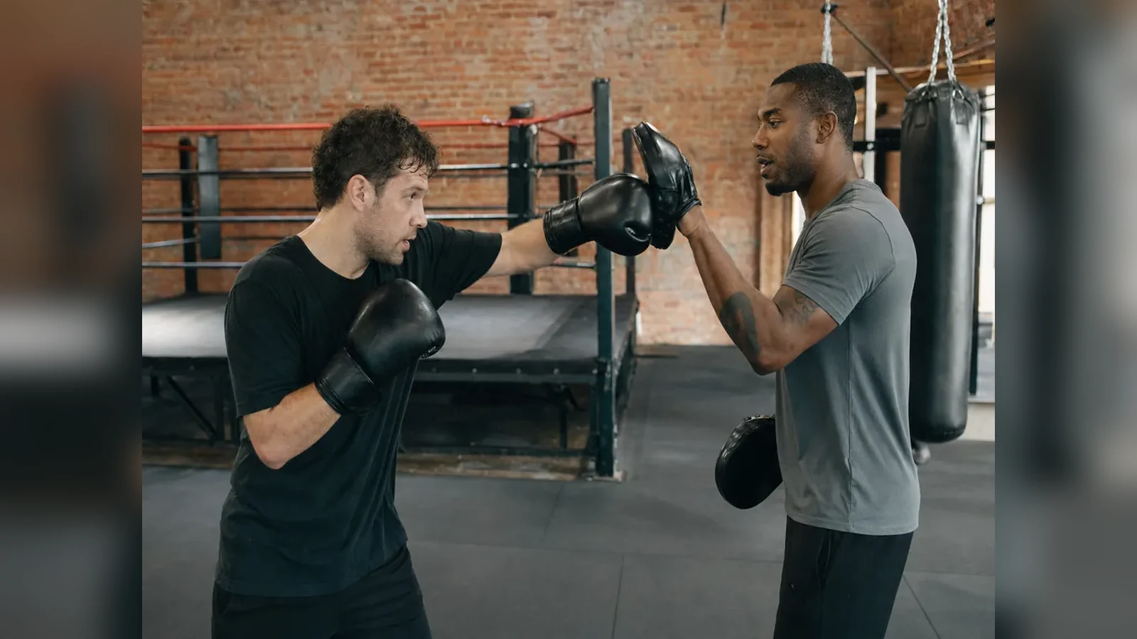 Adult beginner doing controlled boxing pad work with a coach