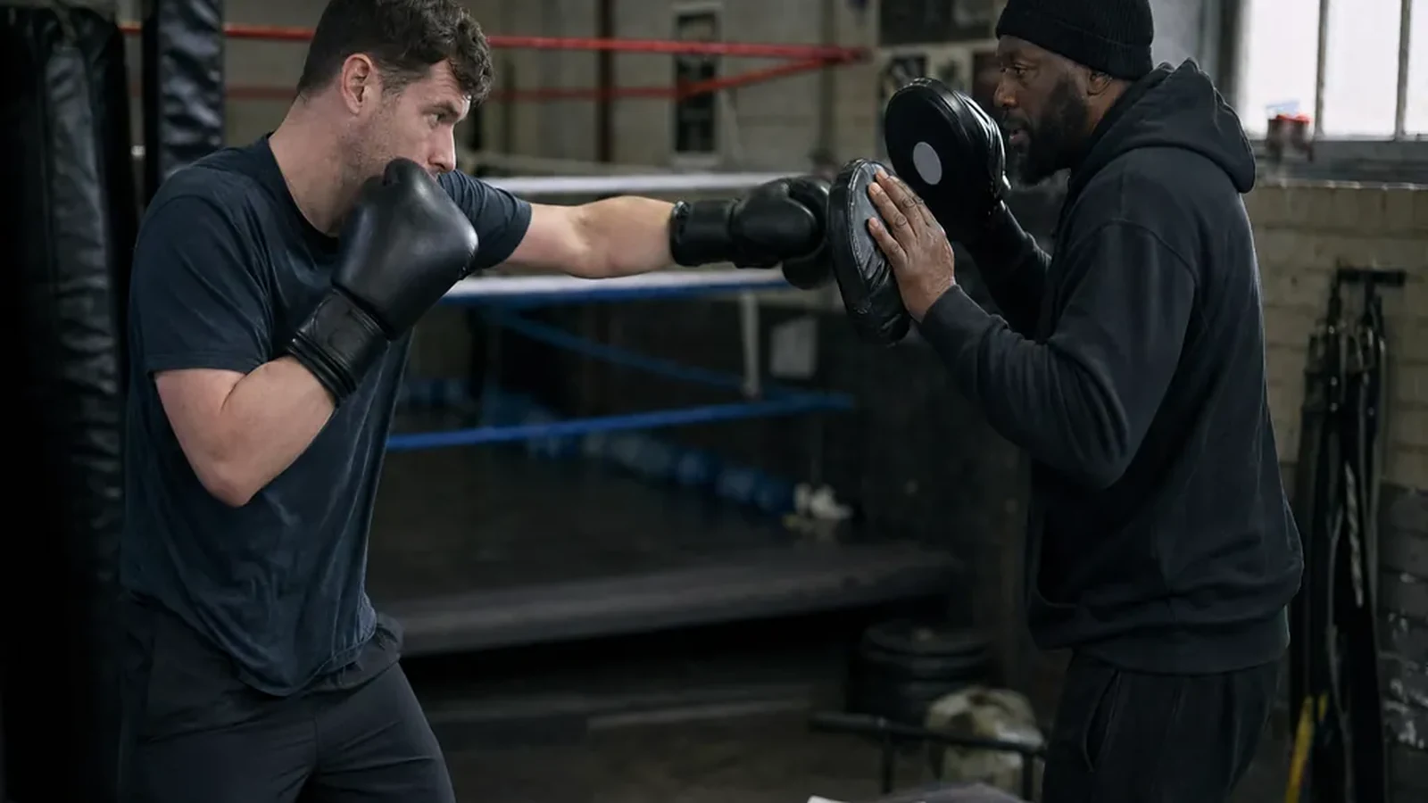 Adult beginner doing controlled boxing padwork with a coach