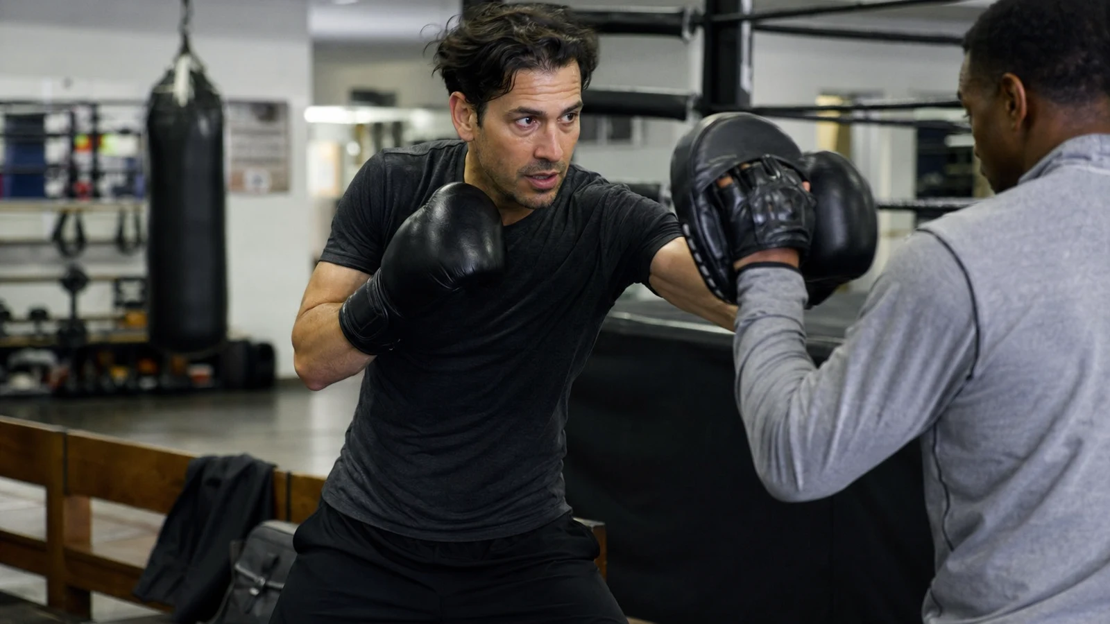 Adult boxer leaving a gym after training with gloves and a work bag
