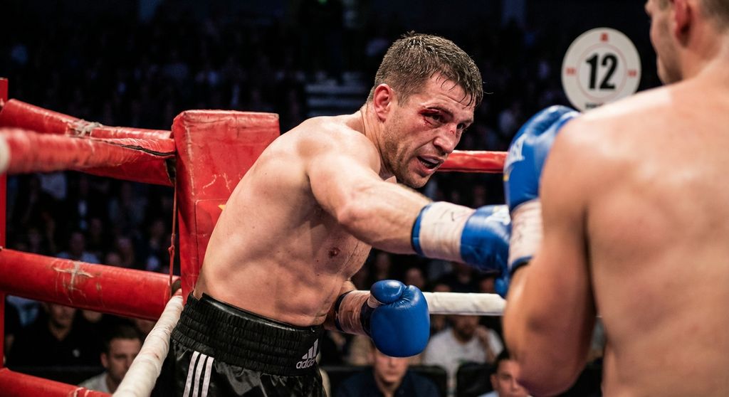 Boxer pushing through fatigue in final round, determination visible on face