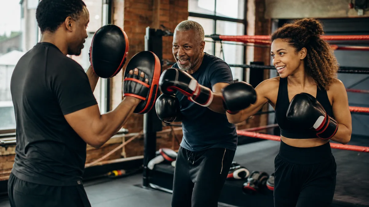 A dad and adult child sharing a beginner-friendly boxing padwork session