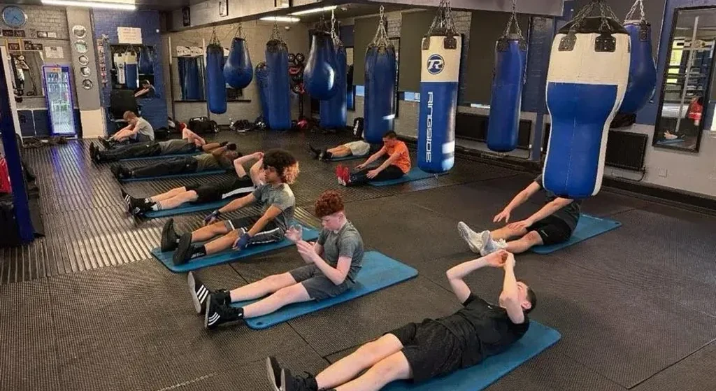 Adult beginner working boxing pads with a coach