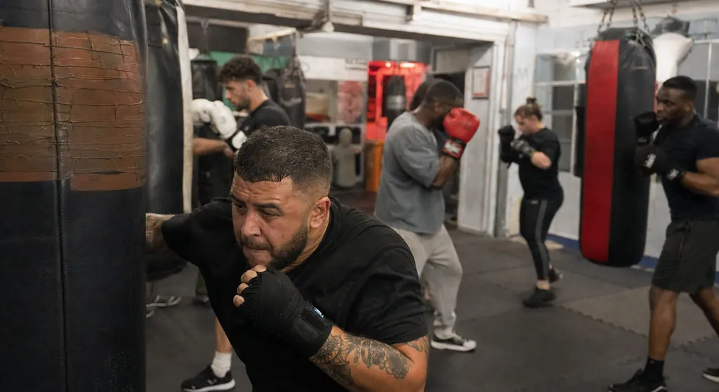 Adult boxer taking a recovery break between rounds during an evening class
