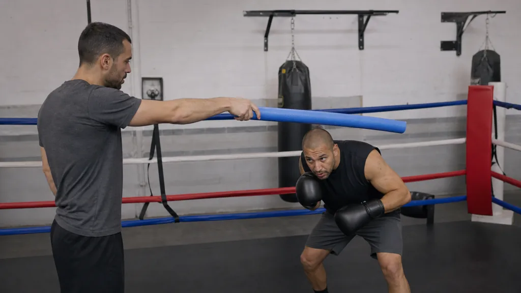 Adult boxer making a compact controlled slip under a soft coaching cue with eyes up and gloves in position