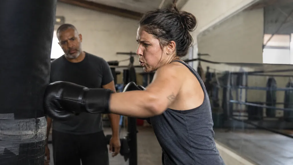 Adult beginner boxer working controlled heavy bag rounds for core fitness