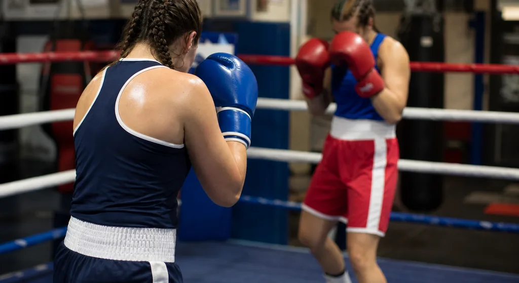 Adult women boxing in a ring during a technical training session