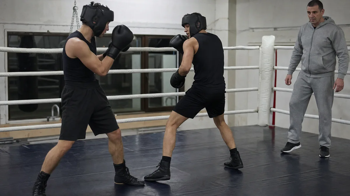 Two amateur boxers working a controlled stance switch during technical sparring