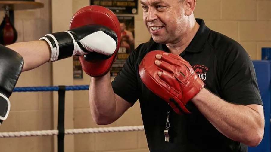 Coach Anton working pads with a boxer at Honour and Glory Boxing Club