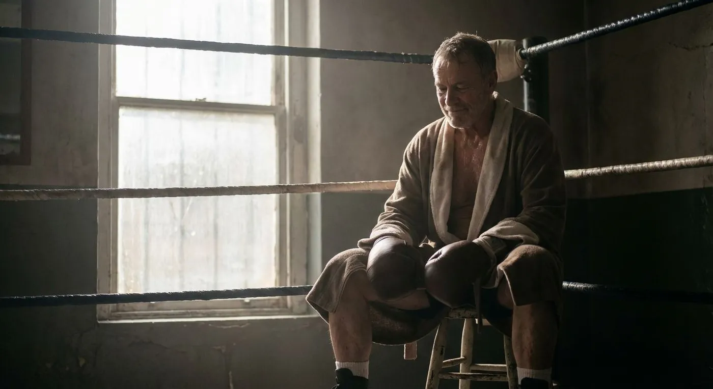 Person focused intently on a heavy bag in a dimly lit boxing gym, finding stress relief through training
