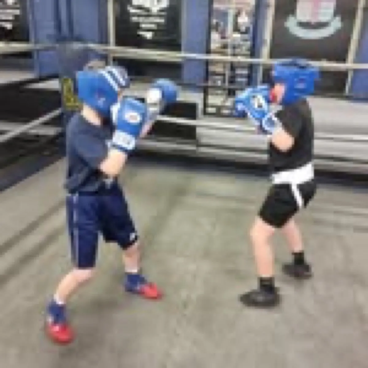 Boxers in headguards practising controlled sparring movement