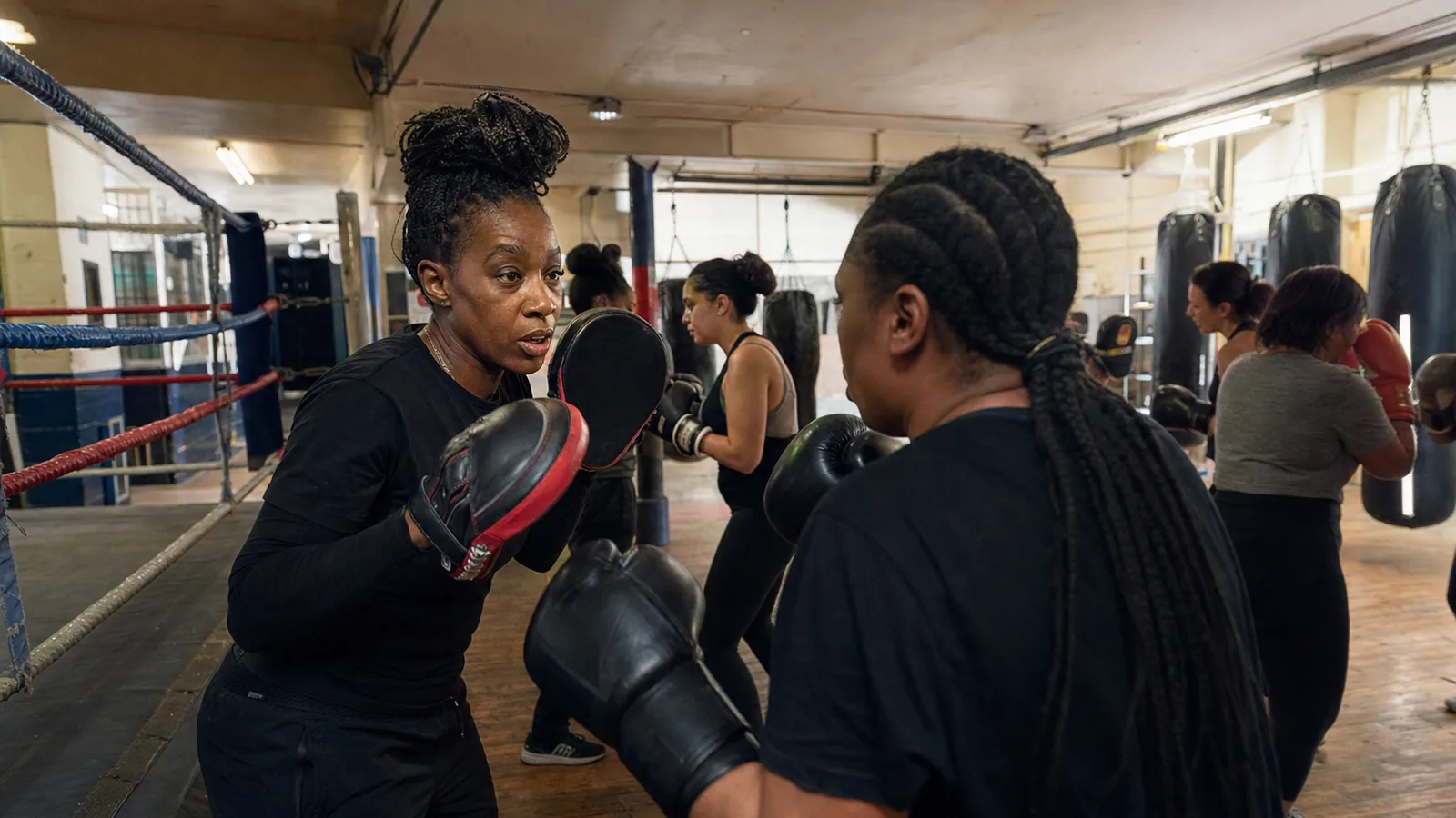 Women learning boxing padwork in a coached Honour and Glory session near Kidbrooke