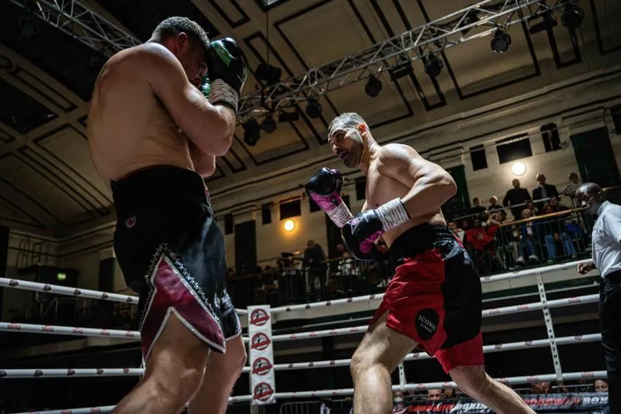 Two professional boxers competing under the lights during a contest